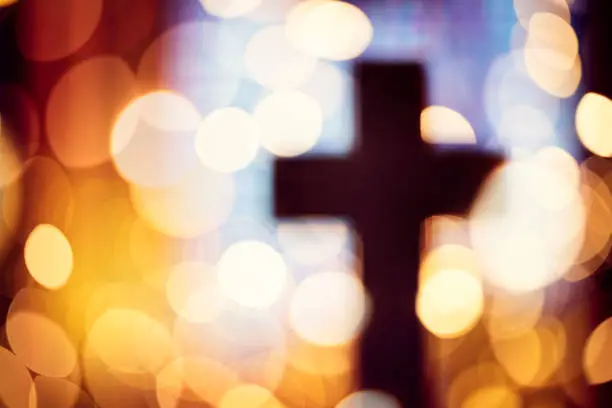 Photo of Abstract cross silhouette in church interior against stained glass window concept for religion and  prayer