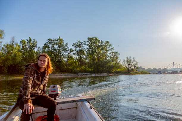 istock Sad man is riding a boat over river in sunset 1288242156