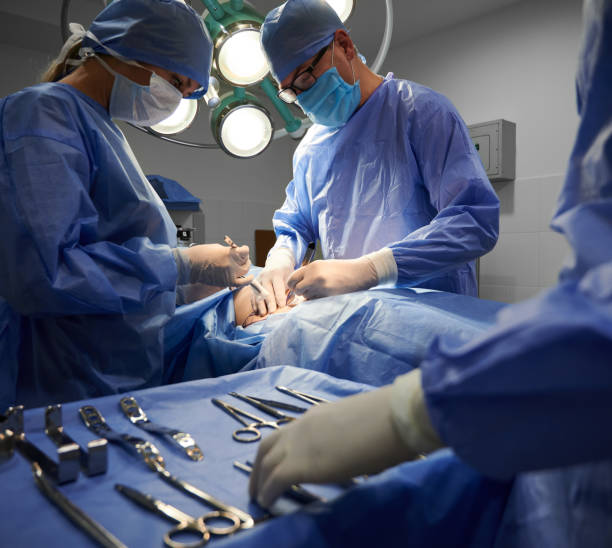 istock Surgical team doing plastic surgery and using medical insturments. 1288244819