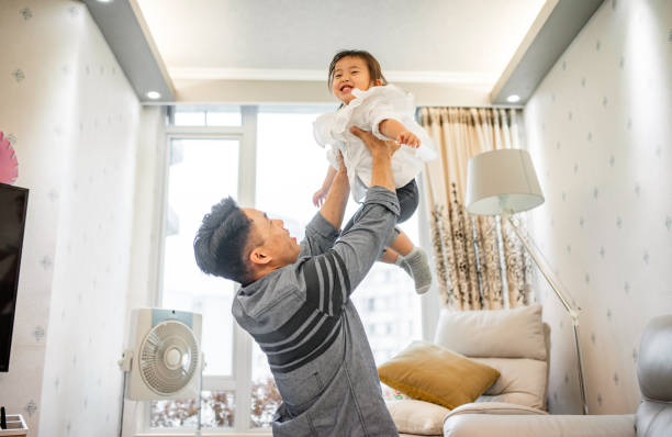 istock Father Lifting 2 Year Old Daughter As They Play at Home 1288247496