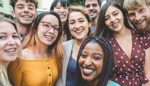 istock Happy millennial friends from diverse cultures and races having fun posing in front of smartphone camera - Youth and friendship concept - Main focus on girl face with yellow shirt 1288253318