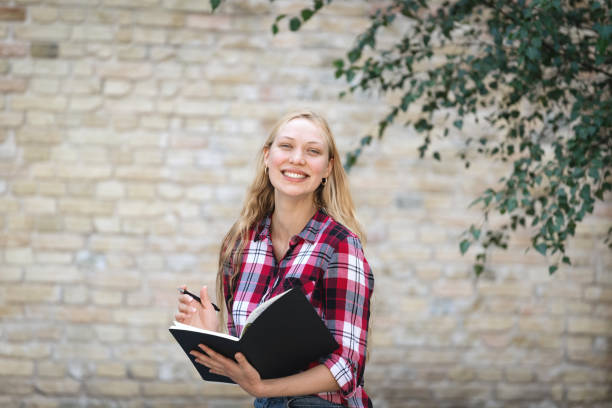 istock Young university student girl with copybooks smiling wide 1288253411