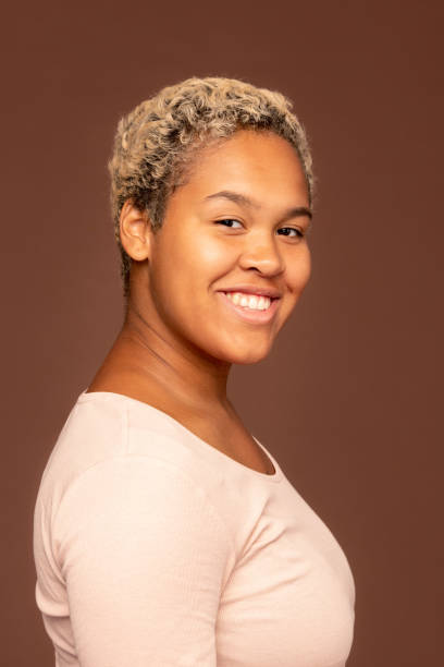 istock Side view of young cheerful mixed-race female in white pullover looking at you 1288254874