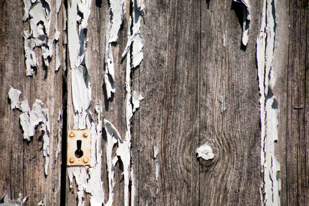 запертая старая дверь, замочная скважина. - peeling paint abandoned old стоковые фото и изображения