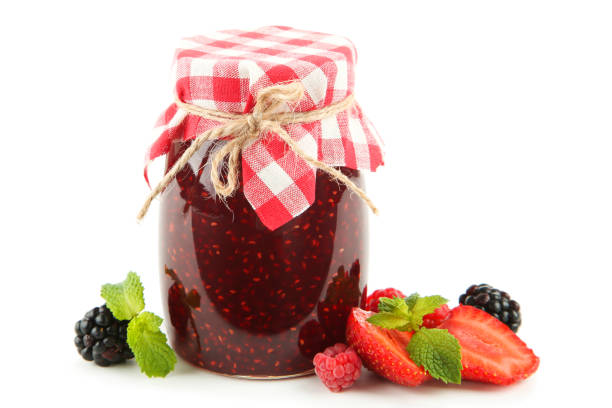 istock Sweet raspberry jam in glass jar with berries isolated on white background 1288255674