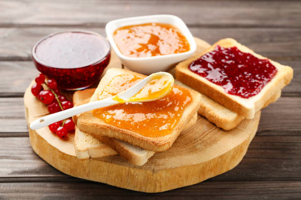 istock Toasts with jam and ripe berries on wooden table 1288257251