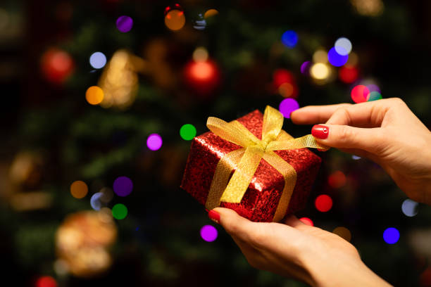 istock Woman's hand holding a Christmas present 1288257372