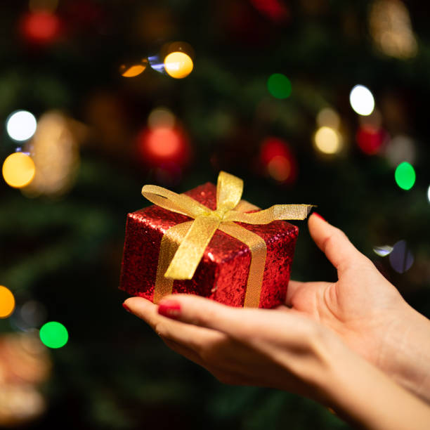 istock Woman's hand holding a Christmas present 1288257373