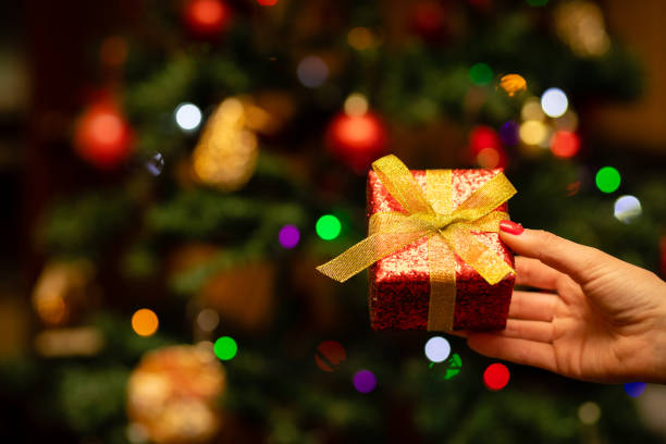 istock Woman's hand holding a Christmas present 1288257398