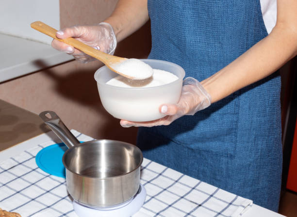 istock Pouring sugar into a metal bucket that stands on a scale. Cooking process. Selective focus. 1288258763