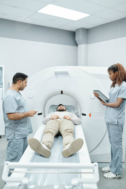 istock Young assistant in uniform and doctor standing on both sides of long couchette 1288262396