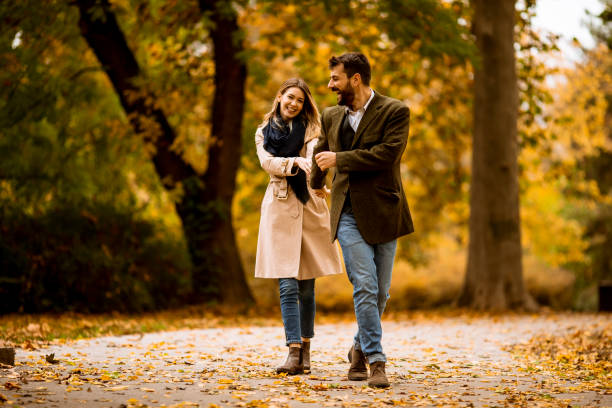 istock Young couple walking in the autumn park 1288263444