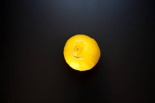 istock Yellow lemon on black table, food background 1288267002