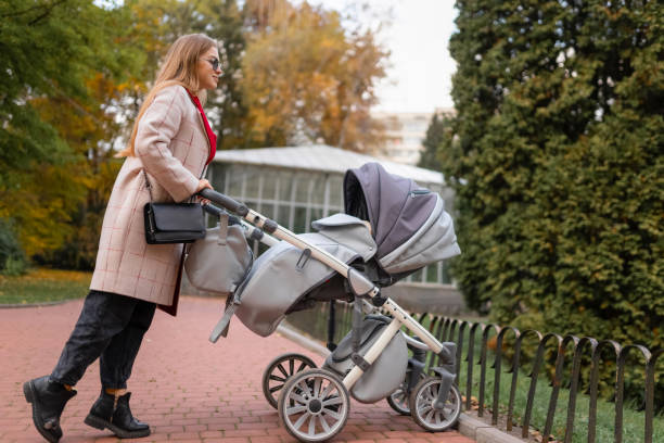 istock Mom with stroller walking in park 1288268480