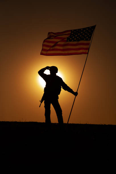 istock US soldier with flag looking far away at sunset 1288268968