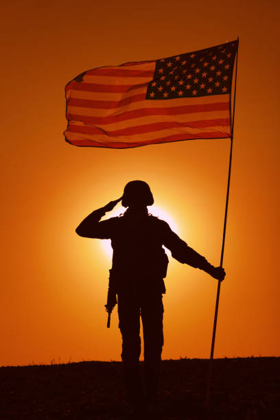 istock USA Soldier with flag saluting on sunset horizon 1288268989