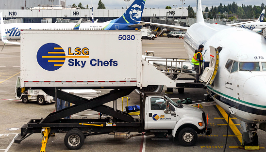 Seattle Tacoma Airport, Washington State, USA - June 2018: Catering being loaded from a LSG Sky Chefs hydraulic scissor lift truck into an Alaska Airlines Boeing 737 jet at Seattle Tacoma airport.