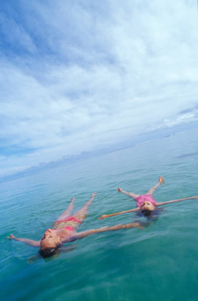 madre e figlia galleggiano nel mare tropicale al mattino - film tilt foto e immagini stock