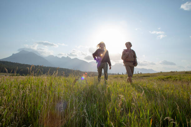istock Friends walk through grassy meadow in the morning 1288271441