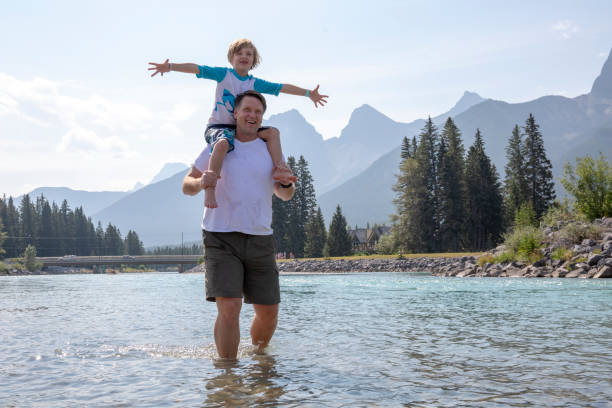 istock Father and son walk along through flowing river in the morning 1288272140