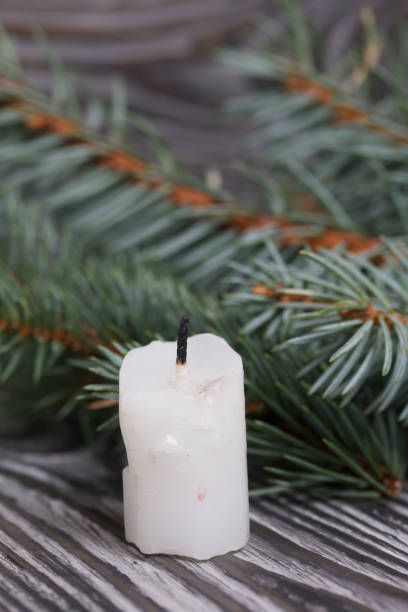 istock Candle stub and fir branches. On black pine boards. 1288272884