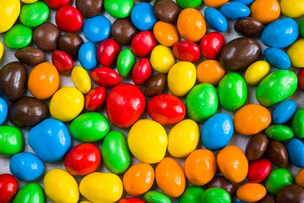M&M's candy on the white background, colorful candy texture, multicolored gradient.
