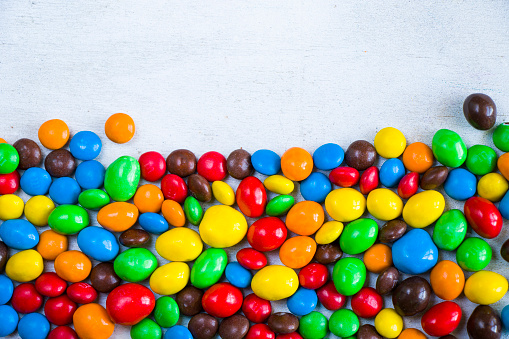 M&M's candy on the white background, colorful candy texture, multicolored gradient.