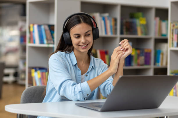 istock Young woman talk on video call at the table using headphones Remote work or learning concept 1288273947