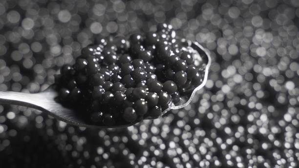 istock Black caviar in a spoon on a background of a rotating background 1288274062