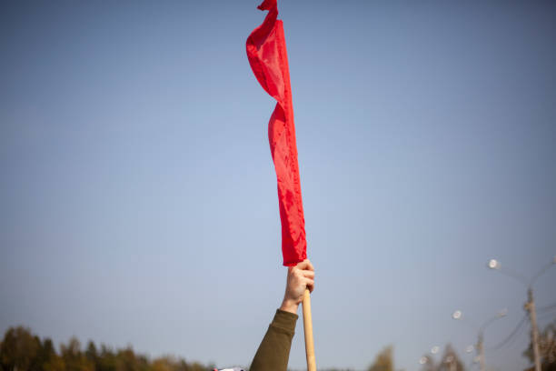 istock Red flag in hand. Workers' protest symbol red banner. 1288274280