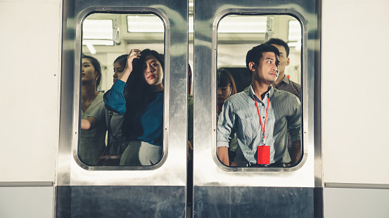 Crowd of people on a busy crowded public subway train travel . Commuting and urban lifestyle concept .