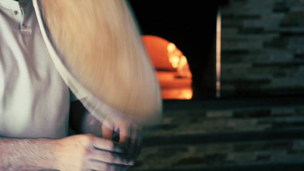 istock hands of pizza chef prepare pizza. preparation gesture with oven on the bottom 1288279638