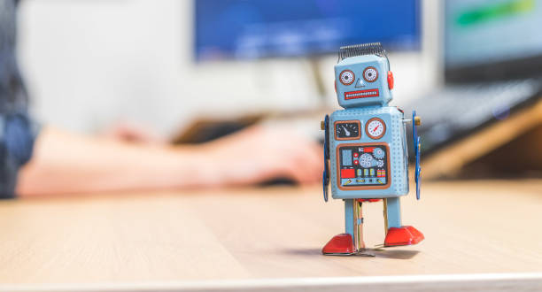 istock Artificial intelligence concept: Toy robot on office desktop. Metaphor for chatbot, social bot and algorithms 1288279795