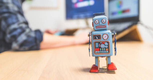 istock Artificial intelligence concept: Toy robot on office desktop. Metaphor for chatbot, social bot and algorithms 1288279893