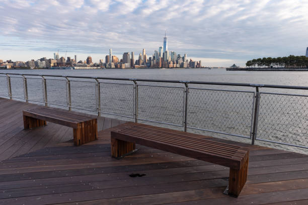 istock Empty Benches in Hoboken New Jersey along the Hudson River Riverfront with a Lower Manhattan New York City Skyline View 1288280390