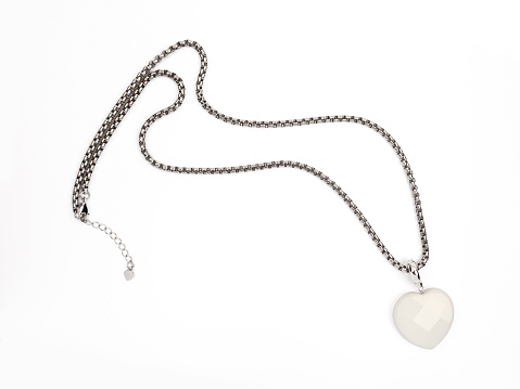 Female white heart shaped agate pendant with golden chain isolated on white background. Close-up shot