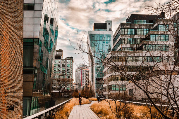 New York, USA - February 11, 2020: Modern glass buildings and walkway along the High Line public park in Chelsea, Manhattan, United States. Touristic place.