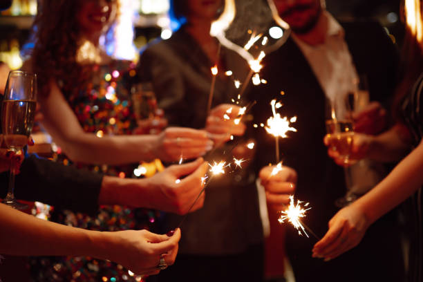 istock Sparkling sparklers in the hand. Celebration, people and holidays concept. 1288290399