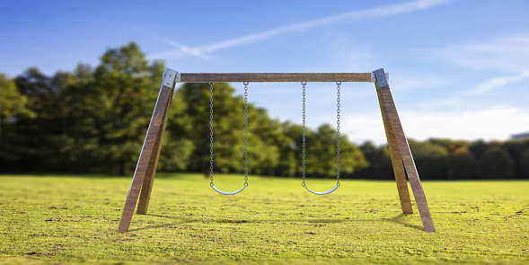 Swing set in the park, sunny day. Playground equipment for kids fun in a green field with trees, blue sky background. 3d illustration