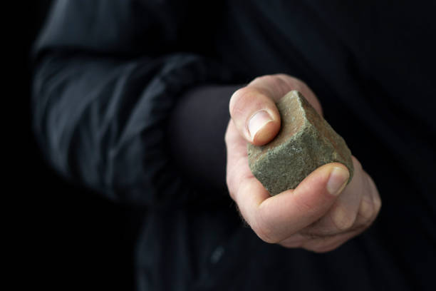 男性の手に石畳。暴動の概念。 - throwing people stone tossing ストックフォトと画像