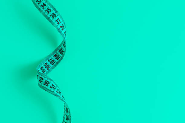 istock Blue meandering measuring tape on blue background. 1288292302