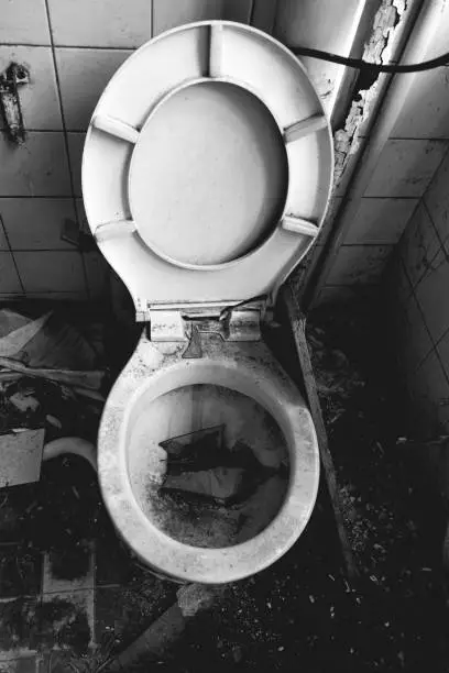 old clogged disgusting toilet in black and white