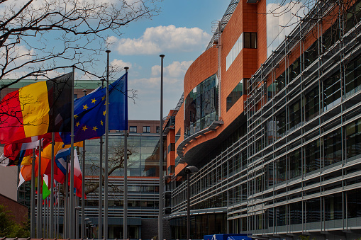 A row of flags at the back of the Jacques Delors building in the European district of Brussels. This building houses the European Economic and Social Committee as well as the Committee of the Regions.