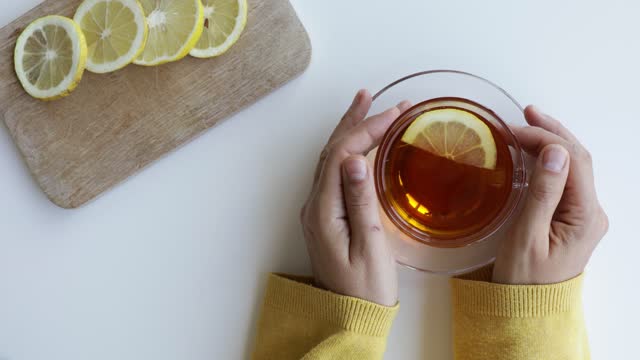 Holding cup of tea with lemon slice
