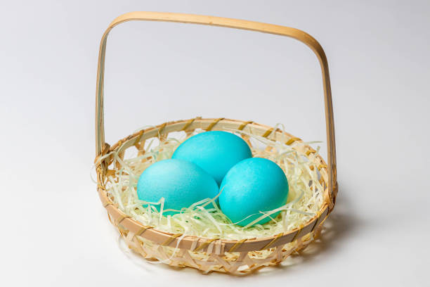 istock Blue Easter eggs in a basket isolated on white background. 1288299298