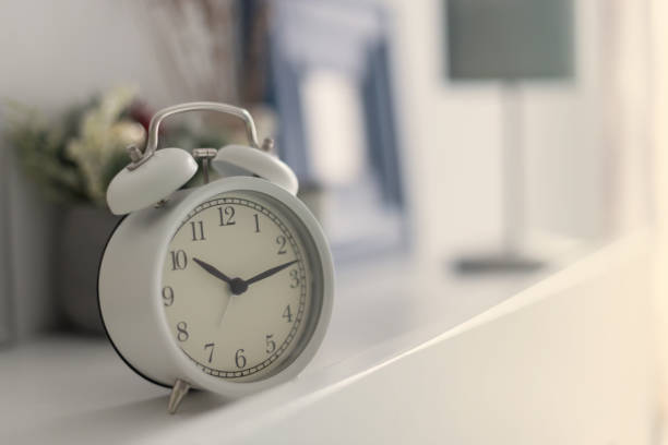 istock White alarm? clock? on bed table in bedroom. 1288301899