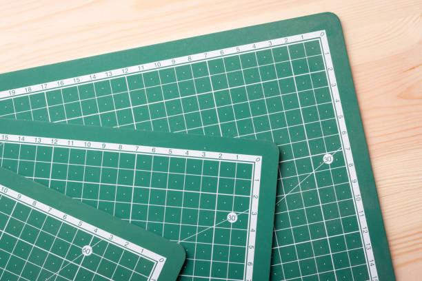 istock Three cutting mats  of different size lay on wooden table before cutting paper 1288302034