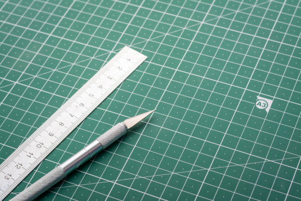 Scalpel for cutting paper and ruler on cutting mat in study