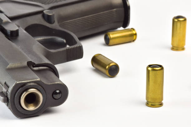 istock Traumatic pistol close up and several cartridges on a white background 1288304913