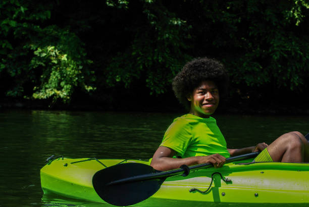 Smiling teenager in a kayak with paddle